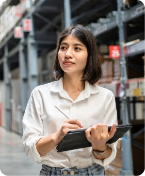 woman in a stocked warehouse with a tablet